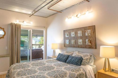 a bedroom with a bed with two lamps and a window at 90 San Luis Street Unit B in Avila Beach