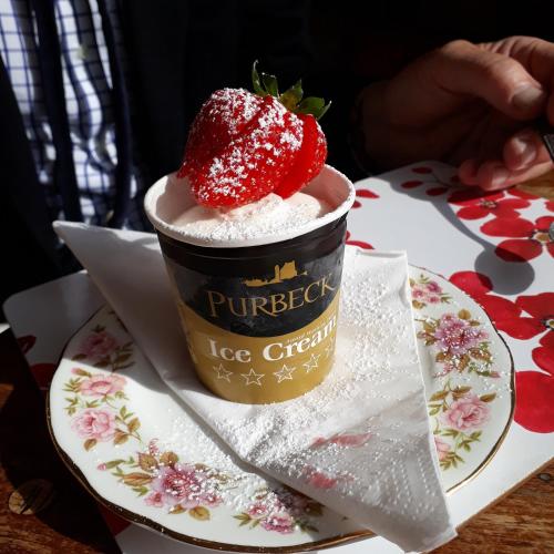 a cup of ice cream with a strawberry on a plate at One Holyrood Hotel & Cafe in Newport