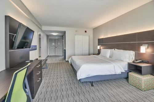 a hotel room with a bed and a flat screen tv at Holiday Inn Express Hotel & Suites Clearwater US 19 North by IHG in Clearwater