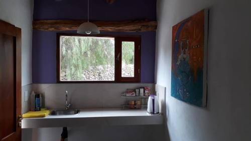 a kitchen with a sink and a window at Cabañas Tilcara Taki in Tilcara