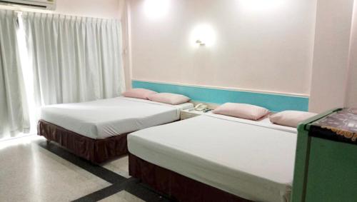 Pokój z 2 łóżkami i oknem w obiekcie Center Mansion at Hatyai w mieście Hat Yai