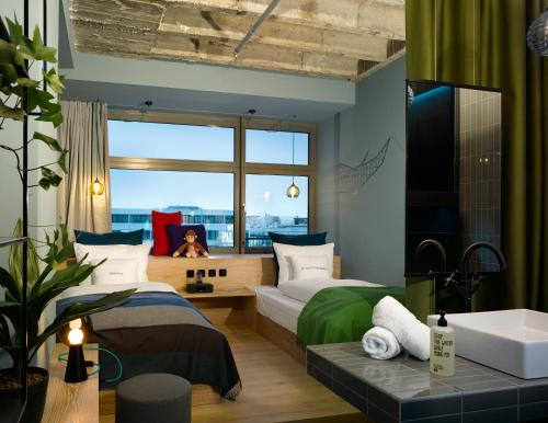 a bedroom with two beds and a large window at 25hours Hotel Bikini Berlin in Berlin
