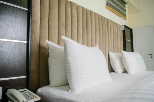 a hotel room with a bed with a phone next to it at Ocean Park Hotel,Lekki phase 1 in Lekki