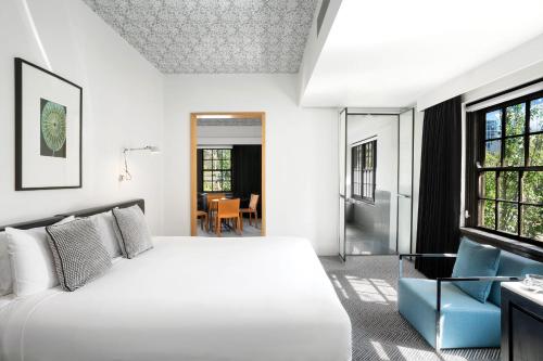 a bedroom with a white bed and a window at Peppers Gallery Hotel in Canberra