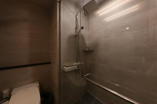 a bathroom with a toilet and a shower at Sejong City Osong Hotel in Cheongju