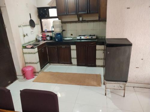 a kitchen with wooden cabinets and a counter top at Mufis Homestay, Emerald Compound, New Palam Vihar-2 in Gurgaon