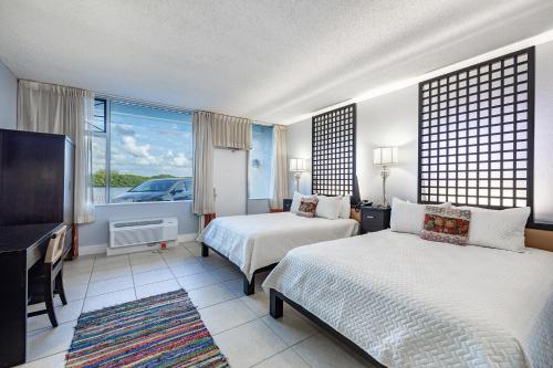 a hotel room with two beds and a flat screen tv at The Artful Nook in Ruskin