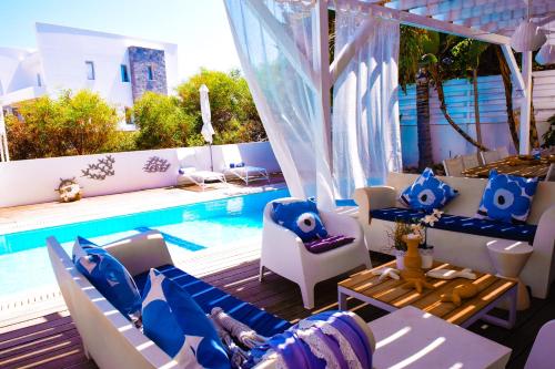 une terrasse avec une piscine, des chaises et une table dans l'établissement Riverland beach villa, à Protaras