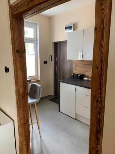 a kitchen with a table and a chair in a room at Magiczne Mieszkanko in Piła