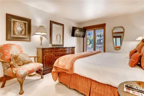 a bedroom with a large bed and a chair at Ski In, Ski Out 1 Bedroom Vacation Rental In The Heart Of Lionshead Village With Heated Slope Side Pool And Hot Tub in Vail