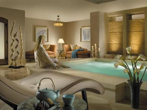 a woman sitting on a tub in a living room at Platinum 4 Bedroom Vacation Rental In The Heart Of Vail That Includes Ski Valet, Ski Deck, Rooftop Pool, Panoramic Views in Vail