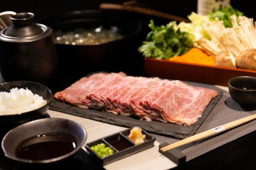 a table topped with a piece of meat and rice at Asama Kuzanbo in Naganohara