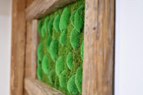 a stained glass window with green moss on a wooden frame at Chalet Apartments Maštal in Železná Ruda