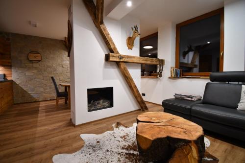 a living room with a couch and a fireplace at Chalet Apartments Maštal in Železná Ruda