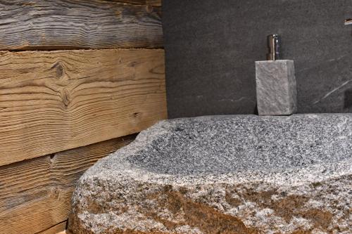 a bathroom with a concrete sink with a soap dispenser at Chalet Apartments Maštal in Železná Ruda