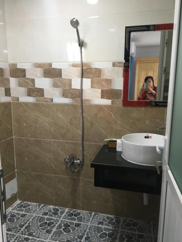 a person taking a picture of a bathroom with a sink at Khánh Vân - VT Cloud mini Hotel in Vung Tau