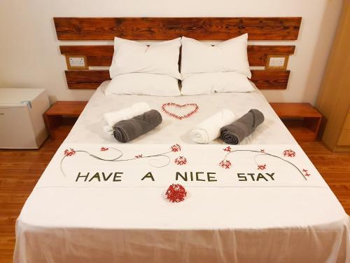 a bed with avisor have a nice stay with towels and hearts at Thoddoo Island Life in Thoddoo