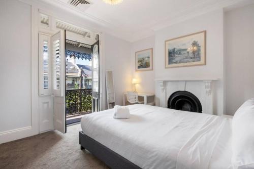 a white bedroom with a bed and a fireplace at BRID243FL - The Terrace on Bridge in Sydney