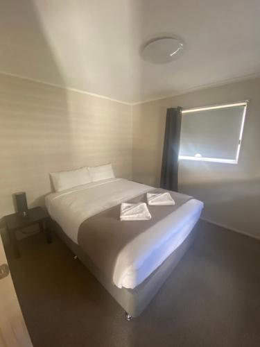 a white bed in a room with a window at BIG4 Moama Holiday Park in Moama