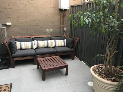 a couch and a coffee table on a patio at BRID243FL-G - Converted Garage on Foss - King Bed in Sydney
