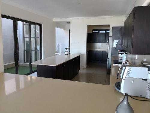 a kitchen with a white counter top in a room at Blissful Beachfront Apartment - 11 Sovereign sands in KwaDukuza