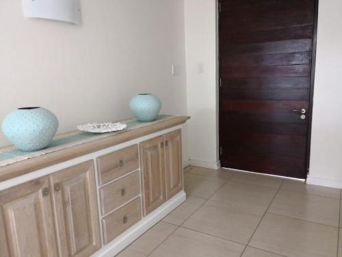 a room with two vases sitting on top of a wooden cabinet at Blissful Beachfront Apartment - 11 Sovereign sands in KwaDukuza