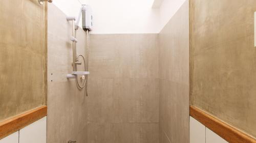 La salle de bains est pourvue d'une douche et d'une porte en verre. dans l'établissement RedDoorz near Fishermall Quezon City, à Manille