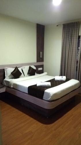 a bedroom with a large bed with black and white pillows at The Majestic Crown in Ooty