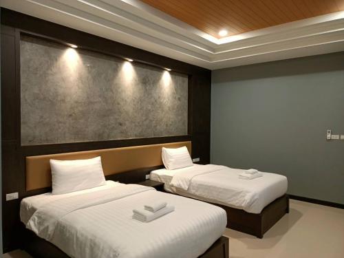 - une chambre avec 2 lits et des draps blancs dans l'établissement น้ำเค็มอินน์ Namkhem Inn, à Phangnga