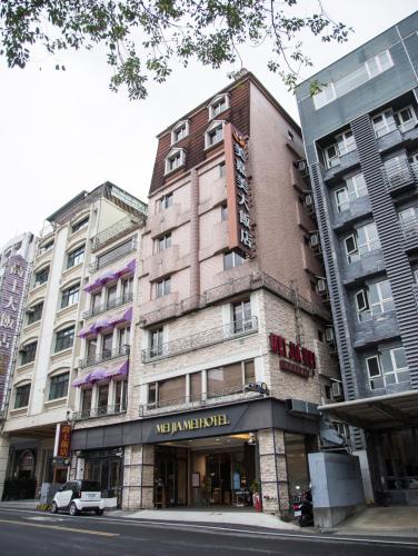a tall building on a city street with buildings at Mei Jia Mei Hotel in Jiaoxi