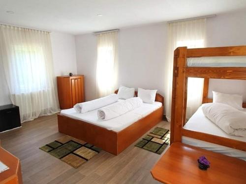 a bedroom with two bunk beds with white sheets at Vila IZVORUL MINUNILOR in Stana de Vale