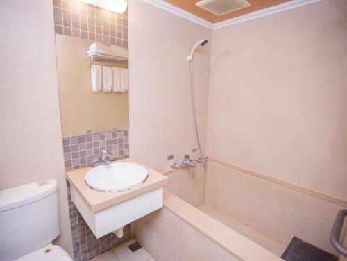 a bathroom with a toilet and a sink and a shower at Mei Jia Mei Hotel in Jiaoxi