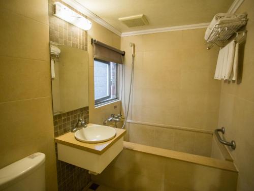 a bathroom with a sink and a tub at Mei Jia Mei Hotel in Jiaoxi