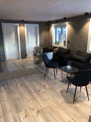 a living room with a couch and chairs and tables at Villa Solsiden Geilo in Geilo