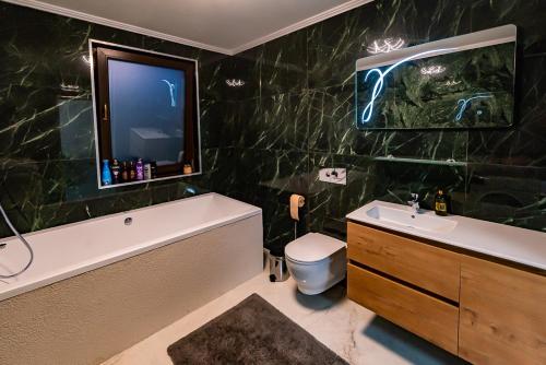 a bathroom with a tub and a sink and a tv at MOKY REZIDENT 2 in Arad