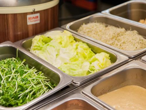 a buffet with trays of cabbage and other vegetables at Mei Jia Mei Hotel in Jiaoxi