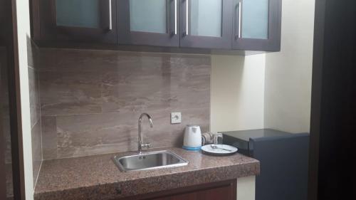 a kitchen with a sink and a counter top at Gunakaya Homestay in Sanur