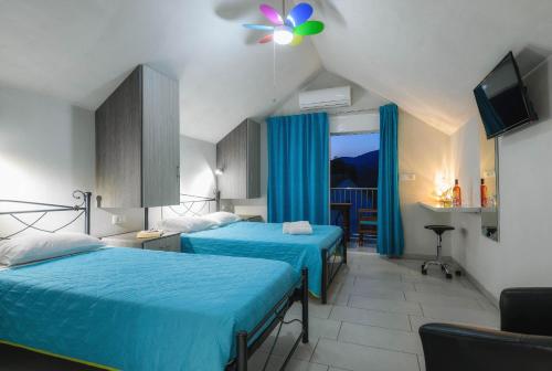 een hotelkamer met 2 bedden en een televisie bij Studio Timotheos in Marathias