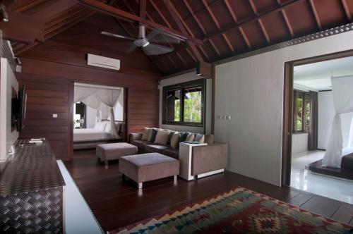 a living room with a couch and a bed at 5BR Villa Sabtu - Minggu Villas Seminyak in Seminyak