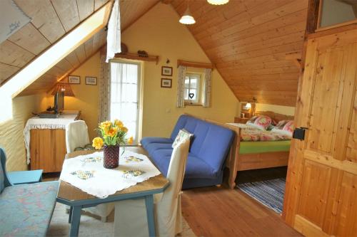 a living room with a blue couch and a bedroom at Altes Gehöft am Lormanberg in Kirchberg an der Raab