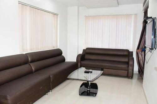 a living room with a brown couch and a table at HOTEL ANAND INTERNATIONAL in Bodh Gaya