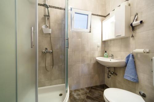 ein Badezimmer mit Dusche, Toilette und Waschbecken in der Unterkunft Apartments Zdravka in Krk