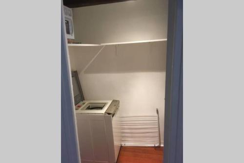 a small kitchen with a refrigerator and a shelf at Victor Hugo 3 G sa pizza offerte in Aurillac