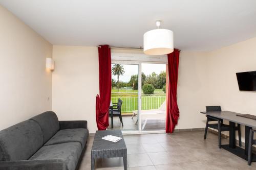 a living room with a couch and a table at SOWELL RESIDENCES Les Perles du Golfe de Saint-Tropez in Grimaud