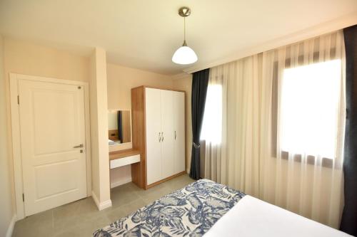 1 dormitorio con cama, ventana y puerta en Fethiye YALI SUITES en Fethiye