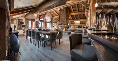 a restaurant with a long table and chairs at La Ferme de Juliette in Le Grand-Bornand