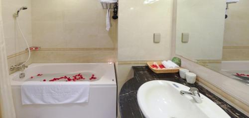 a bathroom with a tub and a sink with red peppers at Khách sạn Công Đoàn Quảng Bá in Hanoi