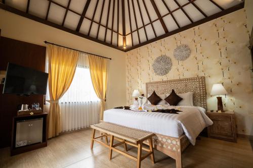 a bedroom with a large bed and a tv at New Sunari Lovina Beach Resort in Lovina