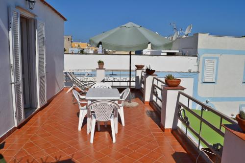 a balcony with a table and chairs and an umbrella at Maridea - Le Conchiglie in Ponza