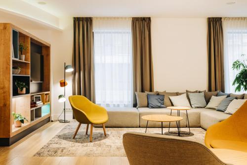 a living room with a couch and chairs at Holiday Inn Łódź by IHG in Łódź